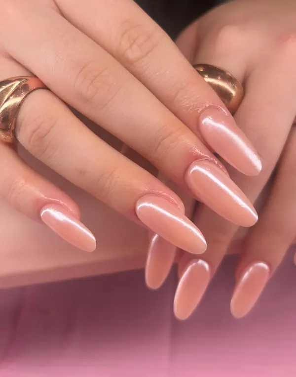 Long almond nails in a sheer nude with a pearly glazed finish